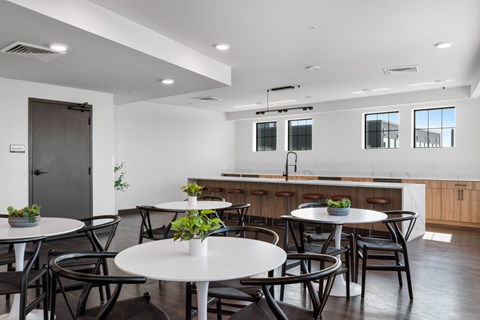 a dining room with tables and chairs and a kitchen